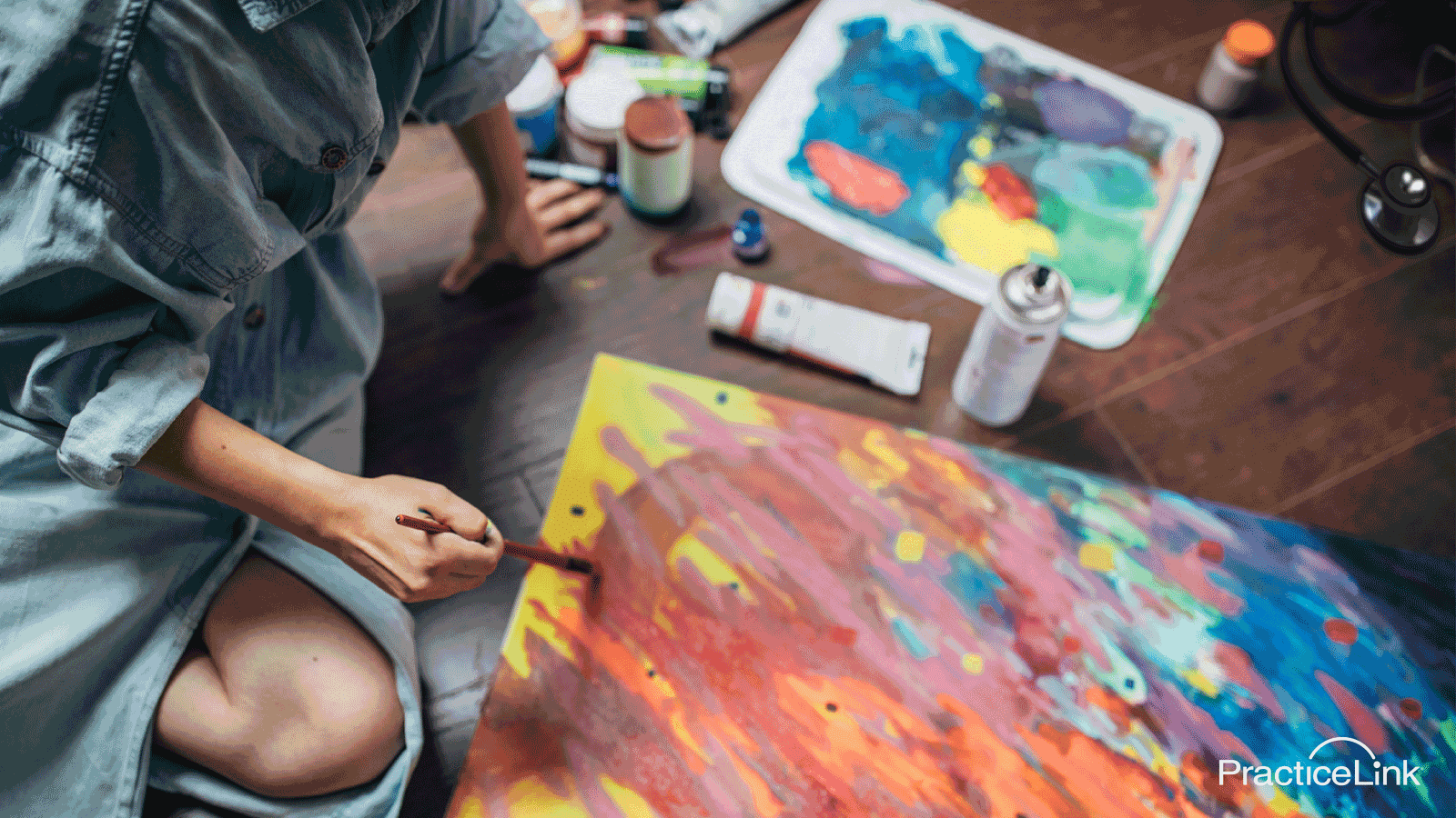 Art supplies and a hand on the table